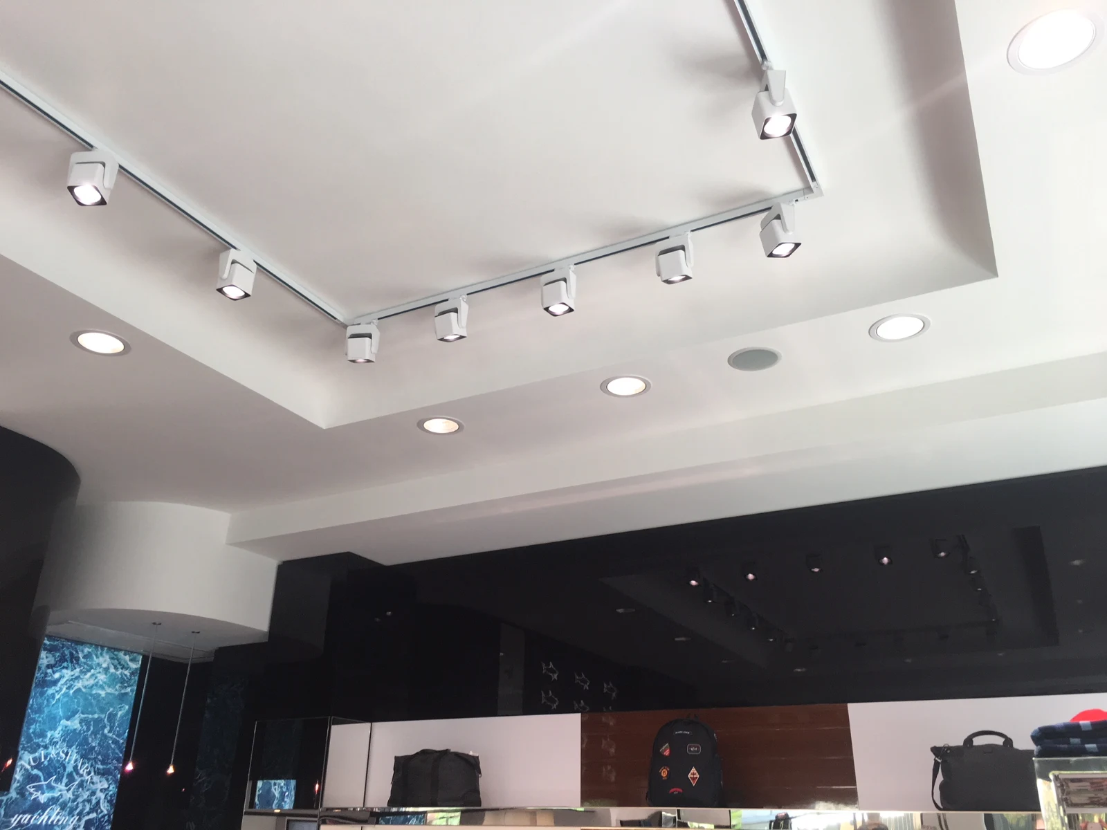 Interno di un negozio con sistema di illuminazione a binario e faretti direzionali.