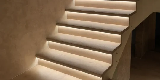 Scala moderna in legno con illuminazione a LED integrata lungo i bordi, in un ambiente interno.