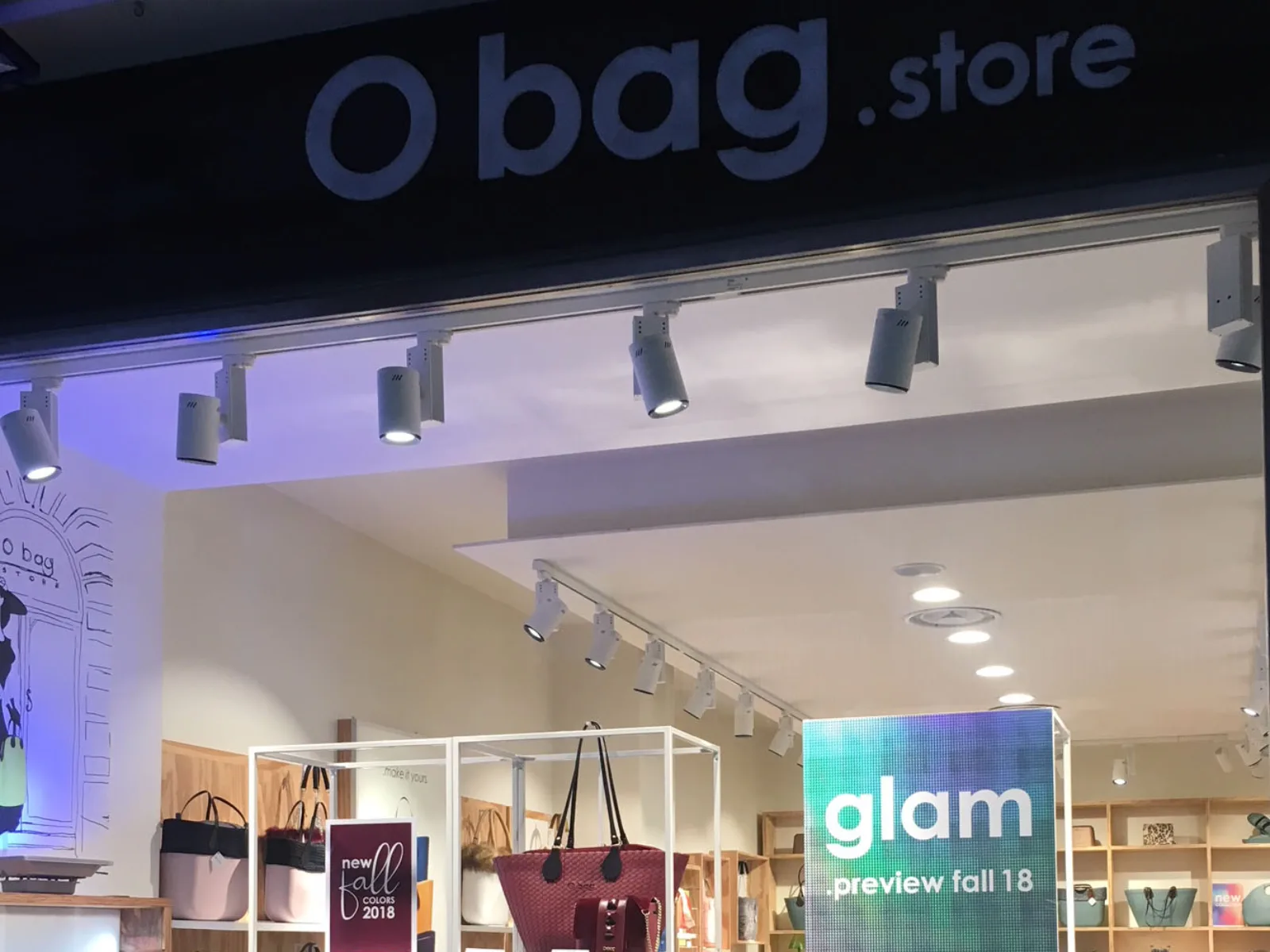 Vetrine di un negozio O bag store con esposizione di borse colorate e cartelli promozionali. I faretti da binario sono a marchio homeled